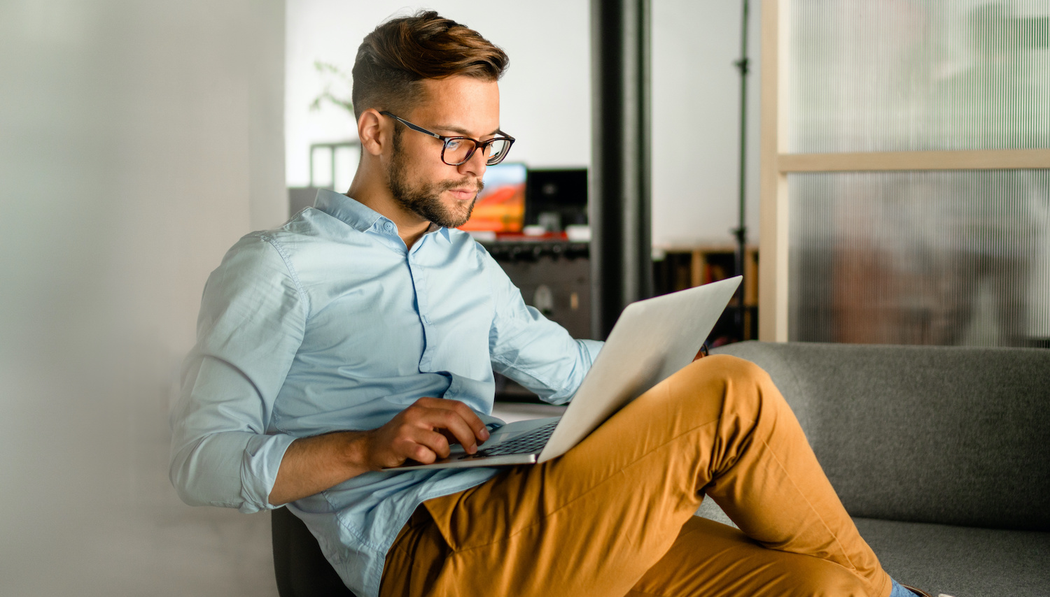 Young smiling Man typing on laptop