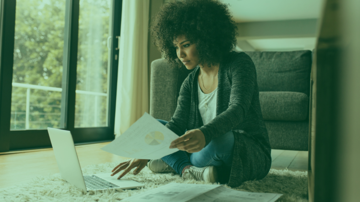 woman on laptop on floor with paper work